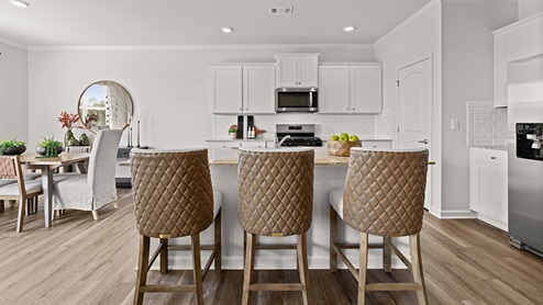 booth kitchen with white cabinets for storage and a walk-in closet