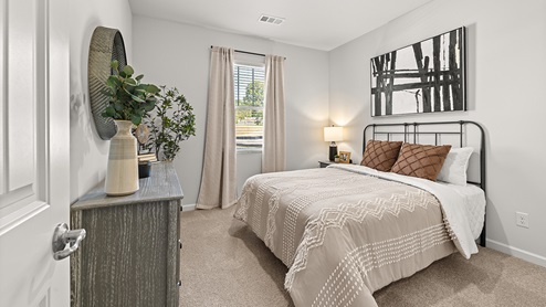 booth secondary bedroom with a window and light carpet