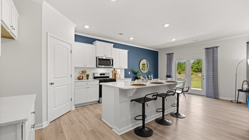 Interior kitchen with center island and white cabinets