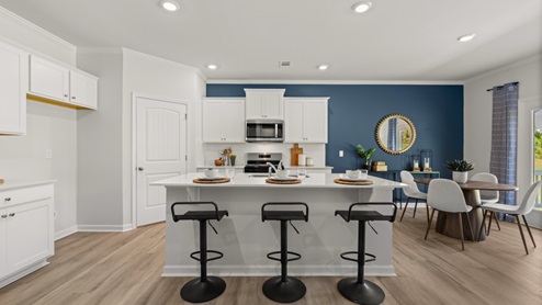 Interior kitchen with center island and white cabinets