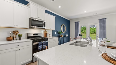 Interior kitchen with center island and white cabinets