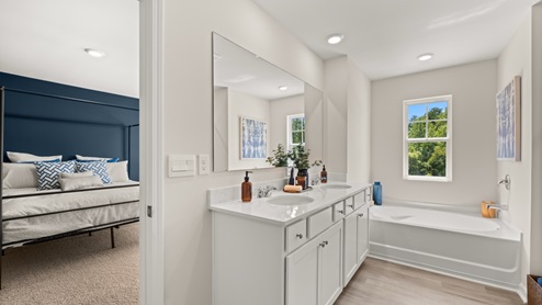 Interior primary bathroom with double sink and bath tub