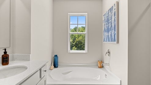 Interior primary bathroom with double sink and bath tub