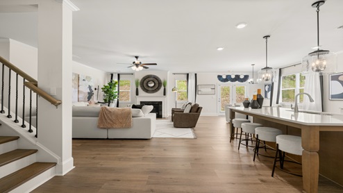 Butner Estates community model home living room with a center gas fireplace with a wooden mantle