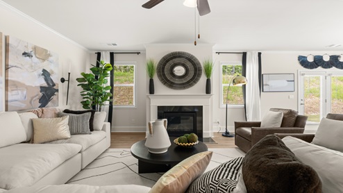 Butner Estates community model home open concept living room with hardwood like flooring and a center ceiling fan