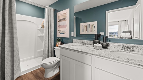 pearson model townhome primary suite bathroom with a walk-in shower and dual vanity