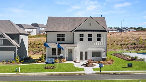 Exterior two-story home with cladding and stone detailing