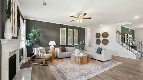 Spacious living room with brown flooring, grey walls and windows