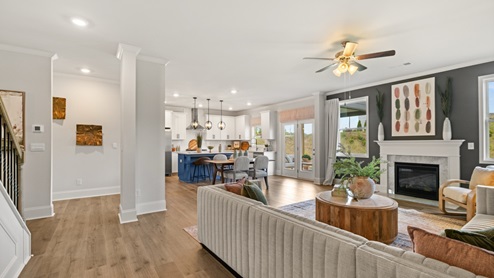 Spacious living room with brown flooring, grey walls and windows