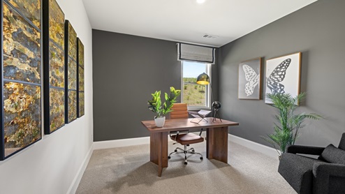 home office with grey walls, a window and a desk