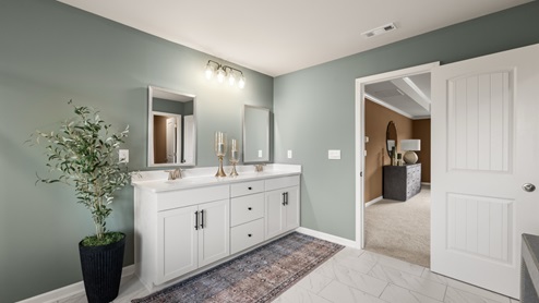 bathroom with dual vanity sinks, toilet, bath tub and a walk in shower