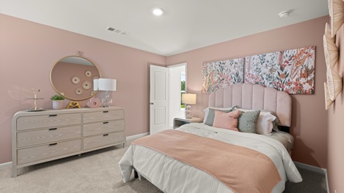 bedroom with pink walls, a bed and a white dresser