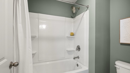 bathroom with dual vanity sinks, toilet and a shower