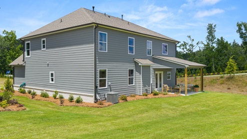 rear exterior of home featuring a spacious backyard