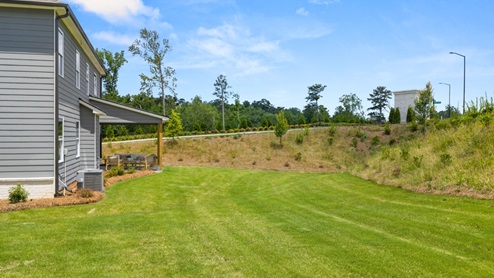rear exterior of home featuring a spacious backyard