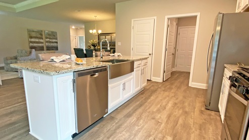 Kitchen area with white shaker-style cabinetry and stainless-steel appliances.