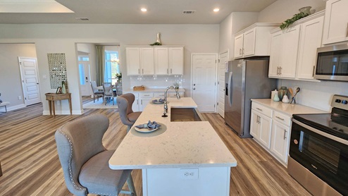 Kitchen with white shaker cabinets and and island with bar seating.