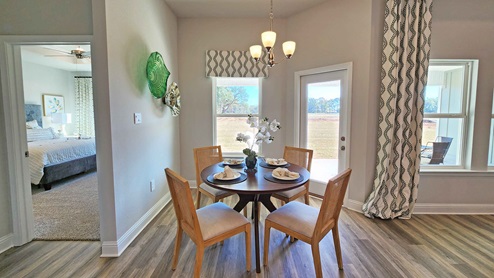 Breakfast room with a dinette table with patio door leading to back covered porch.