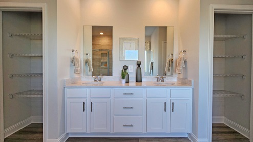 Dual vanity with granite countertops with linen closets.