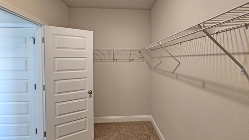 Primary walk-in closet with wire shelving.