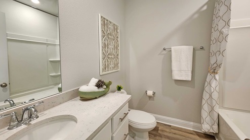 Guest bathroom with single sink vanity and granite countertops.