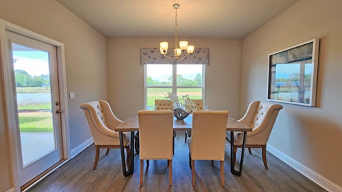 Dining area with windows and patio door leading to back covered porch.
