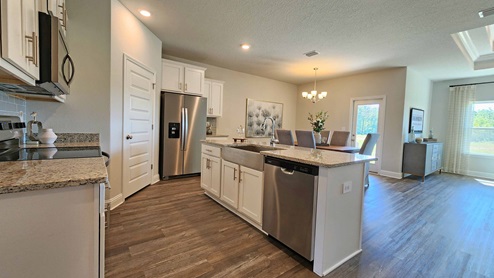 Kitchen island has granite countertops and stainless-steel appliances.