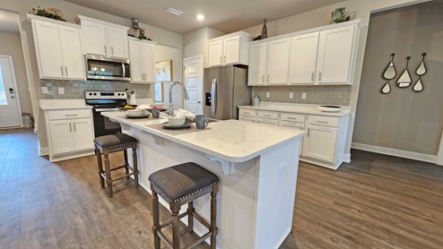 The kitchen with shaker-style cabinetry and granite countertops.