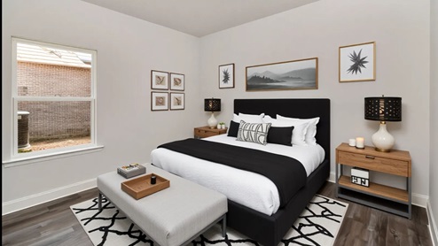 Guest bedroom with window and neutral walls in Coxwell Crossing.