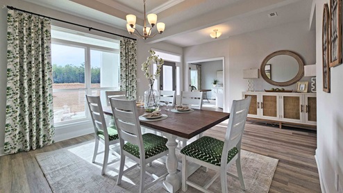 Dining area with chandelier and windows for natural light.