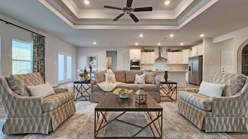 Spacious family area with neutral furnishings and ceiling fan in Cox