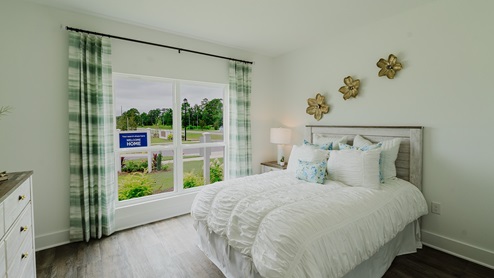 Secondary bedroom with large window overlooking the front yard.