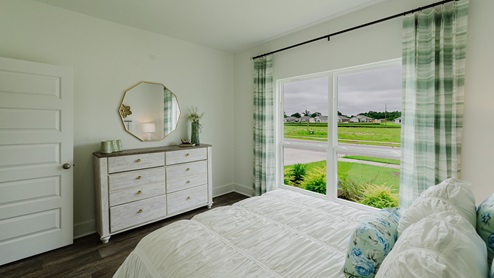 Secondary bedroom with large window overlooking the front yard.