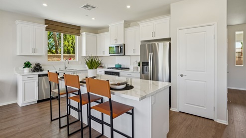 Modern kitchen with white cabinets quartz countertops and stainless steel appliances