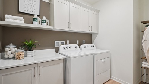 Laundry room with upper cabinets and washer and dryer