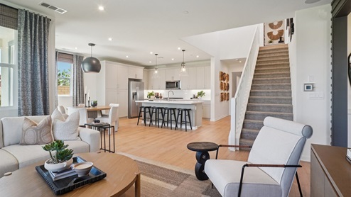 Modern kitchen with light grey cabinets quartz countertops and stainless steel appliances