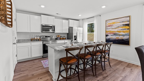 Penwell – Kitchen – 1 - A well-lit kitchen with a wooden dining table and chairs, creating a cozy and inviting atmosphere.