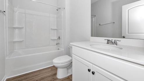 Secondary bathroom with painted cabinets and quartz countertops