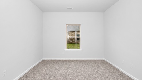 Secondary bedroom with carpet and window