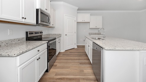 Kitchen island with painted cabinets and stainless steel appliances
