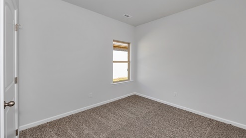 Secondary bedroom with carpet and window
