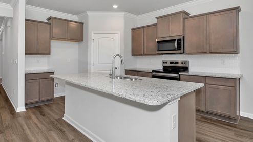 Kitchen island with stained cabinets and stainless steel appliances