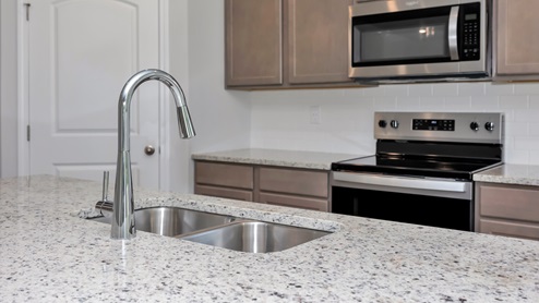 Kitchen sink with granite surround and stainless steel appliances