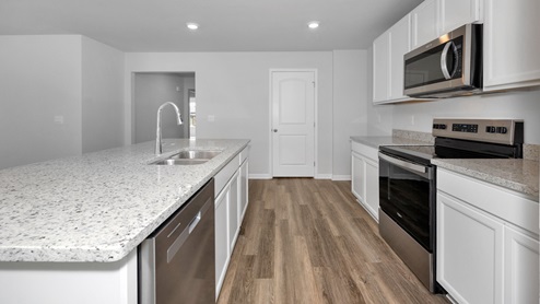 Kitchen island with painted cabinets and stainless steel appliances