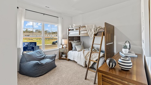 Secondary bedroom with carpet and window