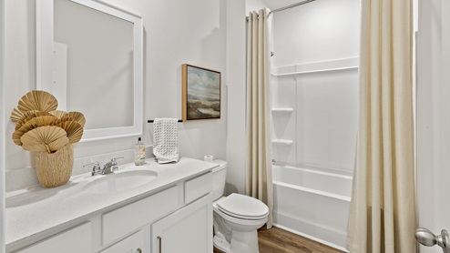 Secondary bathroom with painted cabinets and quartz countertops