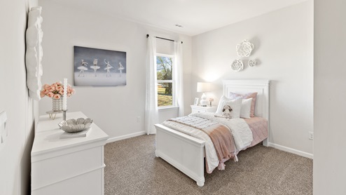 Secondary bedroom with carpet and window