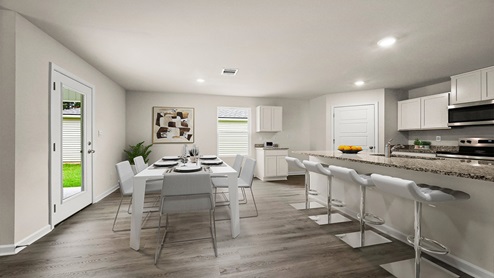 White kitchen island and open dining room with access to patio