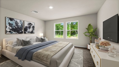 Large primary bedroom with dual windows overlooking the backyard