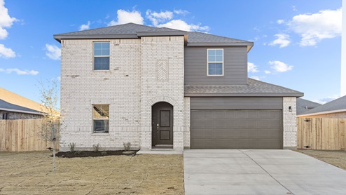 Exterior of two-story modern brick home with spacious front lawn and driveway